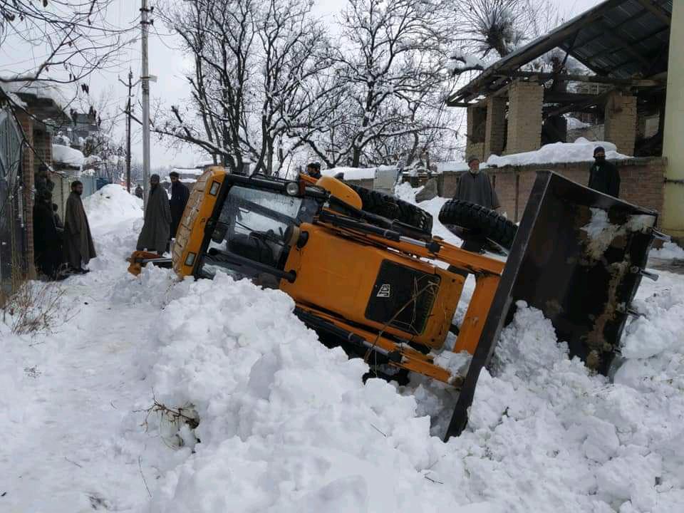 Two injured as JCB turns turtle while clearing snow in Shopian village Two injured as JCB turns turtle while clearing snow in Shopian village